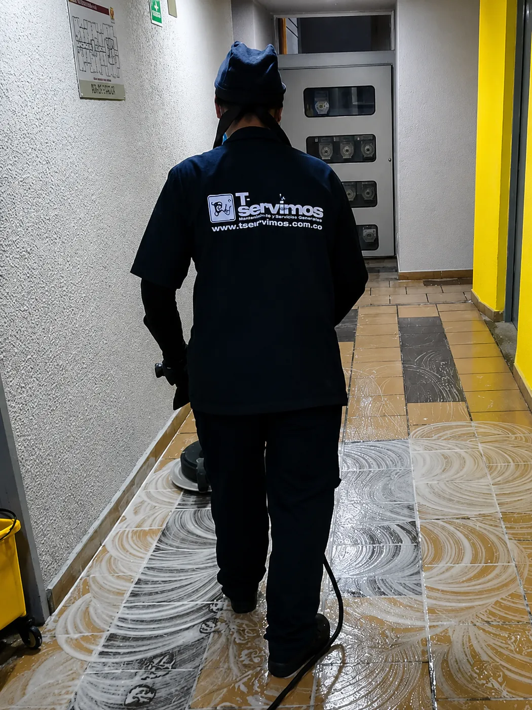 Operario de Te Servimos brillando el piso de un pasillo con brilladora