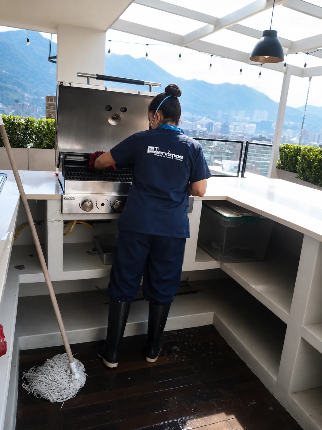 Operaria de Te Servimos realizando limpieza de la zona social de asados en una terraza