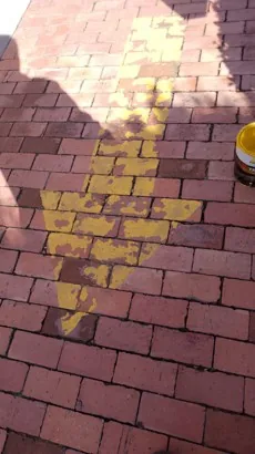 Antes — Flecha de señalización en el piso, con la pintura amarilla descascarada